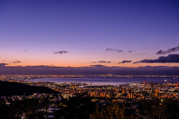 夜明け前の神戸、大阪湾を隔てて大阪の市街地をのぞむ