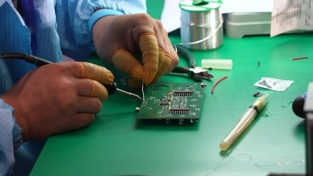 Technicians are using a soldering iron for repairing electronic of the circuit board 