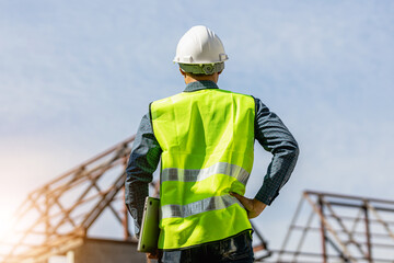 Asian engineer handsome man or architect looking forward with white safety helmet in construction...