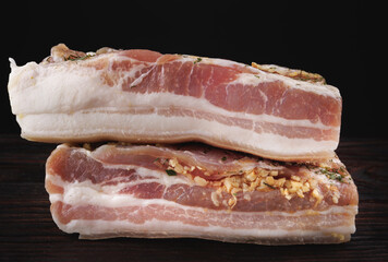 Appetizing salty lard with layers of meat. Salted lard with garlic and herbs.