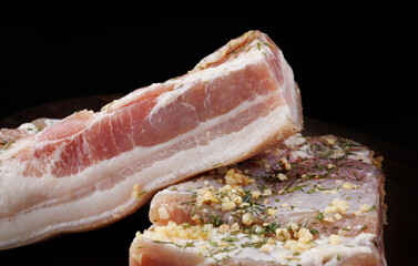 Appetizing salty lard with layers of meat. Salted lard with garlic and herbs.