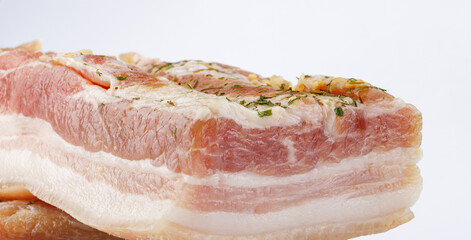 Appetizing salty lard with layers of meat with garlic and herbs. Two pieces of salted lard on a white background.