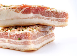 Appetizing salty lard with layers of meat with garlic and herbs. Two pieces of salted lard on a white background.