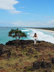 Fototapeta na wymiar girl walking off cliff edge at beach