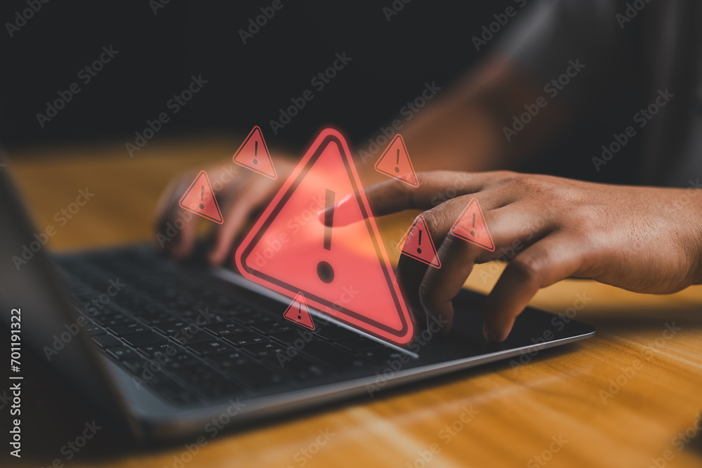 Poster User is using computer with triangle caution warning sign for notification error and maintenance concept. Hacker attacks and hacking data, cyber crime, Ransomware, Phishing, Spyware, cybersecurity.