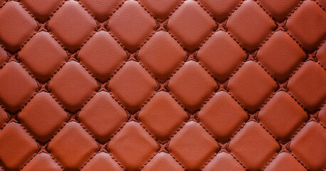 Genuine luxurious of an elegant vintage square pattern brown leather seat car, sofa,cushions,upholstered furniture in retro style with thread pattern, brown leather padded background.Close-up