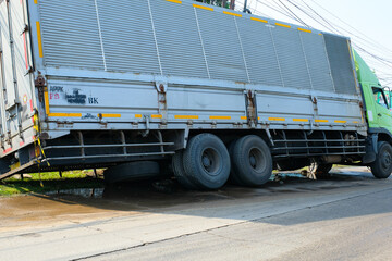 Naklejka premium Transportation Photography. Accident news photo. Photo of a container truck overturned on the side of the road. A truck rolled over on the side of the road in the morning. Bandung - Indonesia, Asia