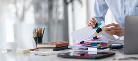 Businesswoman hands working in Stacks of paper files for searching and checking unfinished document...