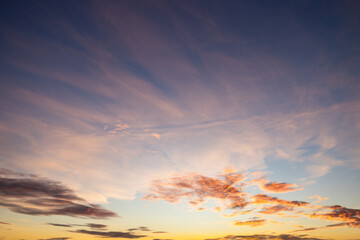 A beautiful sky tinted by the sun leaving vibrant shades of gold, pink, blue and multicolored. Clouds in the twilight evening and morning sky. Cloudy sky background in the evening and during the day.