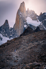 Men trekking to the top of mountain with Mt.Cerro torre as background and beautiful sunset (Patagonia, El chalten, Argentina)