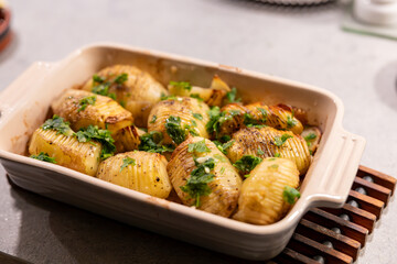 Stockholm, Sweden Baked and sliced Hasselback potatoes with butter in an oven dish.