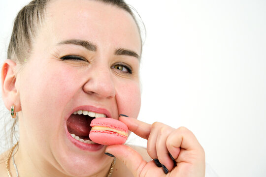 satisfied and happy woman eating macaroons on white background space for text advertising sweets goodies pleasant life pleasure buzz joy smile overweight model size plus