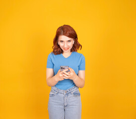 Using mobile phone,  portrait of pretty red bob hair woman using mobile phone. Wear ear buds...