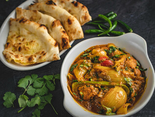 Naan with spicy chicken curry served with lavender and green chili.