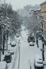 Aerial view. The city is covered with snow. Cars are stuck in snowdrifts.