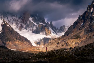 Papier Peint photo autocollant Cerro Torre A tiny woman standing alone in the Agostini campsite surrounded by mountain range in the morning with Mt.Cerro torre as background (Patagonia)