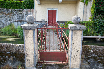Access bridges spanning river to reach some private gardens and backyards in nay french village