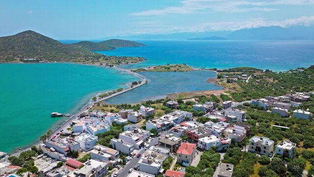 Beautiful Greek houses on the Island of Crete in municipality of Agios Nikolaos. Elounda Town in Greece by the coast with beaches and turquoise mediterranean Sea