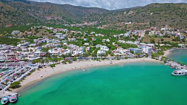 Scenic beach with calm turquoise water on the Island of Crete in Greece in 4K. Greek Paralia Schisma Elountas Compact Beach. Calm waters pedal boat umbrella rentals by Mediterranean Sea