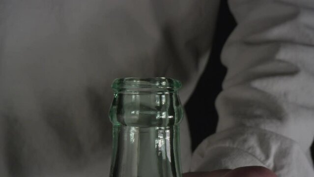 close-up shot of a soda bottle being opened