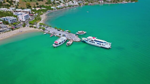 Scenic beach with calm turquoise water on the Island of Crete in Greece in 4K. Greek Paralia Schisma Elountas Compact Beach. Calm waters pedal boat umbrella rentals by Mediterranean Sea
