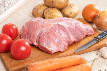 Raw ingredients on table in kitchen, cooking stewed potatoes with meat. Soup with meat, potatoes, carrots, parsley, garlic, pork, parsley. Cooking in multi cooker.