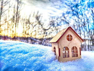 Wooden toy house on snow, natural abstract background. winter season concept. Christmas and new year holidays. symbol of cozy, loving family home. construction, sales, rental concept. copy space