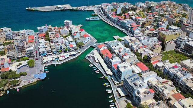 Aerial panoramic view of Agios Nikolaos City on Crete Island in Greece in 4K. Sunny summer City day on Mediterranean Island with turquoise water. Paralia Kitroplatia, Ammos, Yachting Sailing Cruises