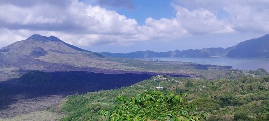 Panoramic view of a volcanic landscape with lush greenery and a tranquil valley.