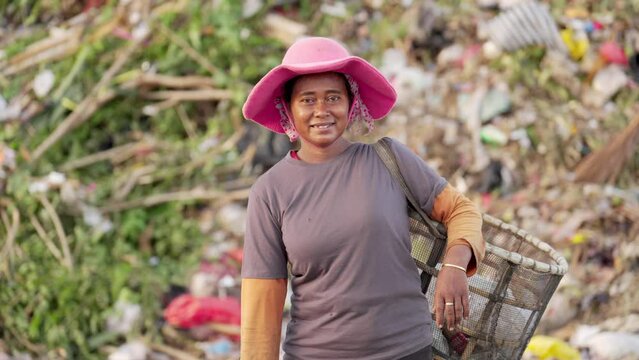 Portrait, optimistic asian female landfill worker in southeast asia, real people