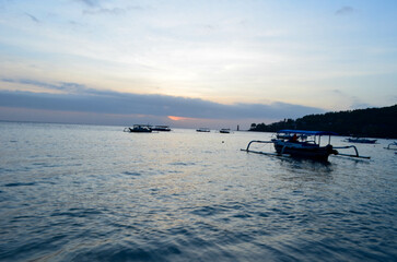 Obraz premium The beauty of Senggigi Beach at sunset with boats that decorate the beautiful beachfront