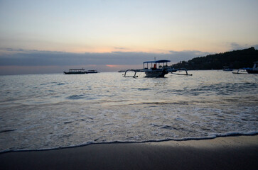 Obraz premium The beauty of Senggigi Beach at sunset with boats that decorate the beautiful beachfront