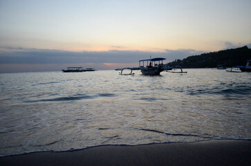 Obraz premium The beauty of Senggigi Beach at sunset with boats that decorate the beautiful beachfront