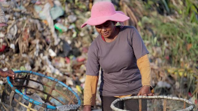 Asian woman collecting recyclables at landfill, garbage economy and resale