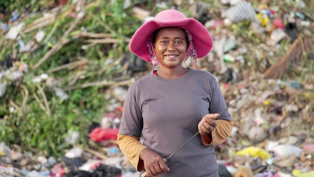 Portrait, female asian garbage or waste picker scavenging landfill for survival