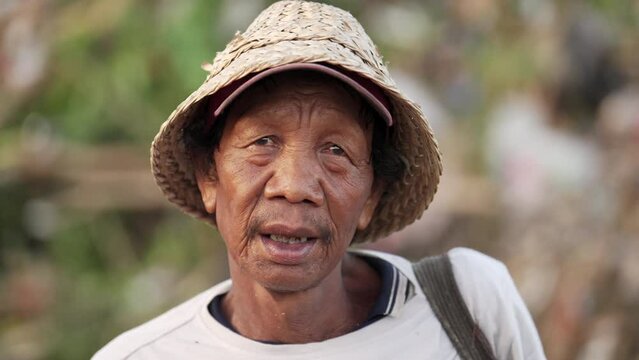 Portrait, poor asian waste picker or scavenger with weathered face in rural asia