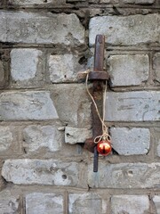 Atmospheric Christmas card with XMAS red ball on rusty hook in old Brickwall. Grunge Christmas postcard. 