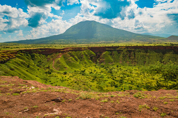 Panoramic view of Shimo la Mungu - God's Pit at the edge of Makonde Plateau with Mount Ol Doinyo Lengai in the background in Tanzania