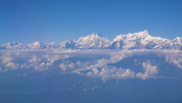 Mountain range shot from the same level of mountain's height, aerial shot of mountains and cloud in a blue sky 