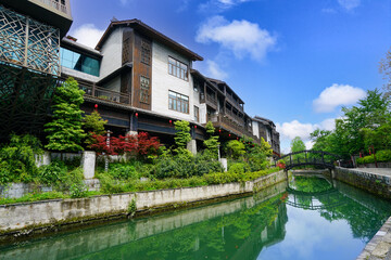 Fototapeta na wymiar Wooden houses, green rivers, lush vegetation. Beautiful scenery. Zhoushui Ancient Town is a historical and cultural attraction. Chongqing, China.