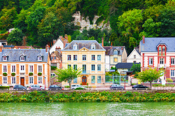 Fototapeta na wymiar The coast of the Seine River in France in the suburbs of Rouen with beautiful private houses and dense green vegetation and mountains.