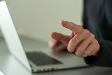 Finger pointing to laptop screen with important technology news. Businessman pressing virtual...