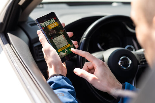 Man use mobile phone in the car, betting on sports