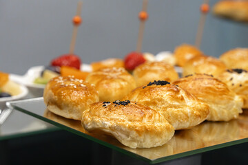 Buns with poppy seeds on a glass table. Buffet. Close-up