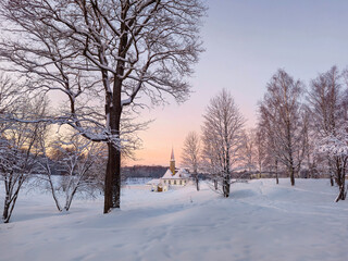 Sunny winter frosty sunset. Evening snowy landscape with old Maltese palace in beautiful natural landscape. Gatchina. Russia.