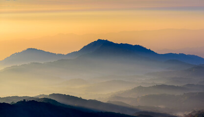 Obraz premium Mountain range with in sunrise sky, mountain ridge view from Doi Inthanon mountain peak with sunrise light, Chiangmai Thailand.
