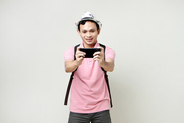 Asian man backpacker take photo with mobile phone. digital nomad and travelling concept. on isolated background