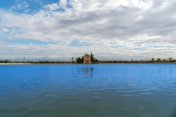 Photo of the Menara Gardens in the city of Marrakech. Photo of the lake with the house at the end of the lake. The house reflected in the lake. Cloudy day.
