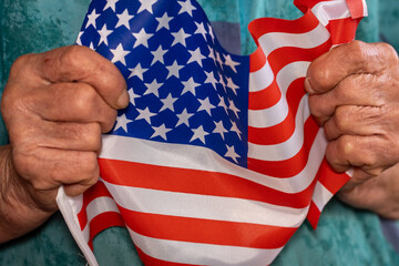 Old woman clutches an American flag in her hands, Patriotic concept, Older Americans, US elections