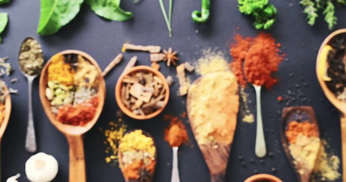 Spices, herbs and condiments for seasoning, spoon and studio for curry powder, leaves and seeds. Food, natural and variety for organic, chilli and cookbook for ingredients, dark backdrop and india